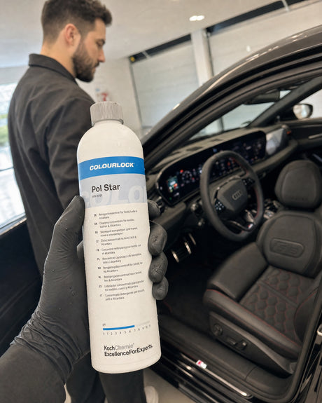 Daniel hält das COLOURLOCK Pol Star Reinigerkonzentrat an der offenen Tür des schwarzen Audi RS 5, Ledersitz dahinter.