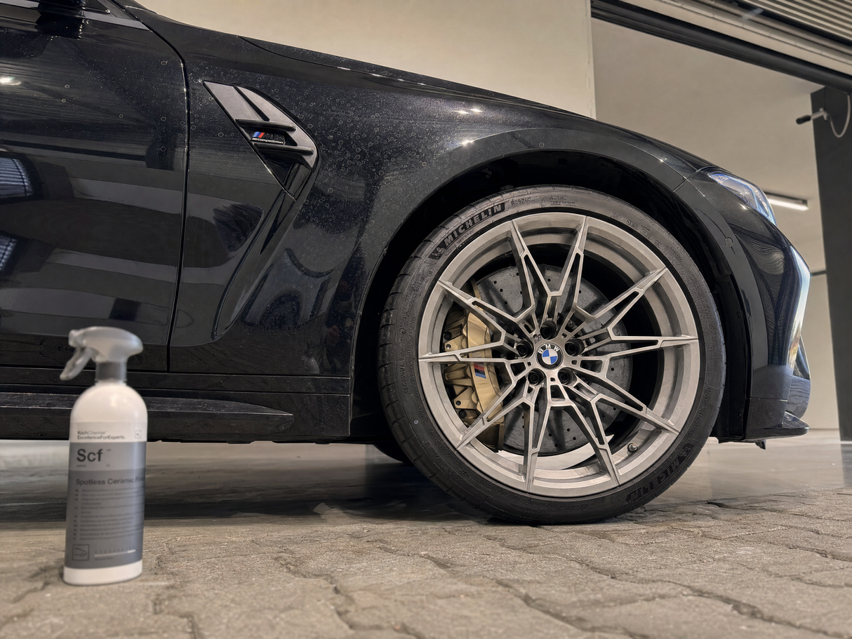 Schwarzer BMW M3 mit Wasserflecken auf der Keramikversiegelung neben Koch-Chemie Spotless Ceramic Finish 500 ml