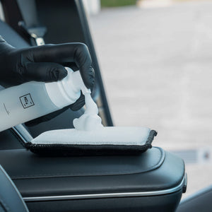 Detailing1 COLOURLOCK Leather Cleaner (Mild) — cleaning foam on the pad next to a black leather armrest